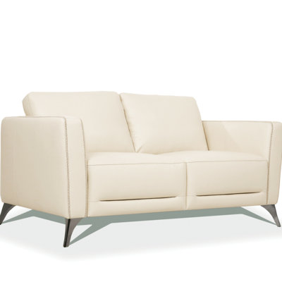 Causeuse en cuir avec assise profonde et pieds chromés élégants, parfaits pour les espaces de vie modernes et confortables