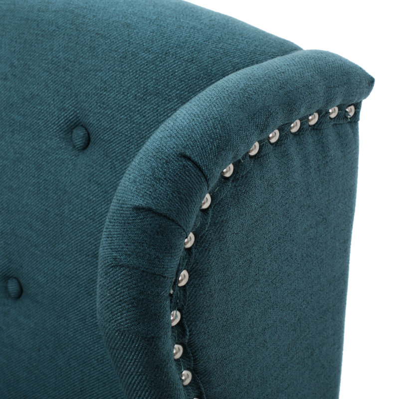 Fauteuil à oreilles classique bleu sarcelle avec pieds décoratifs et bordure cloutée