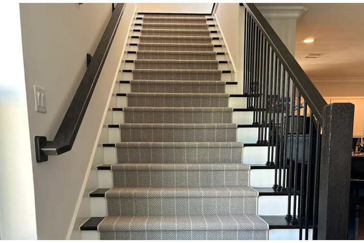 Black and white stairs with black railings and a gray stair runner.