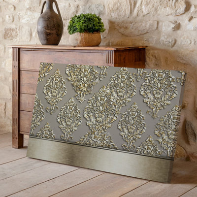 La toile crée un design de papier peint élégant avec un motif damassé complexe en or chatoyant contre un taupe doux