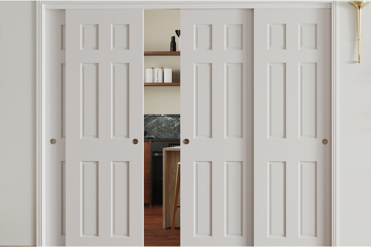 white sliding closet doors partially open to reveal shelves and workspace