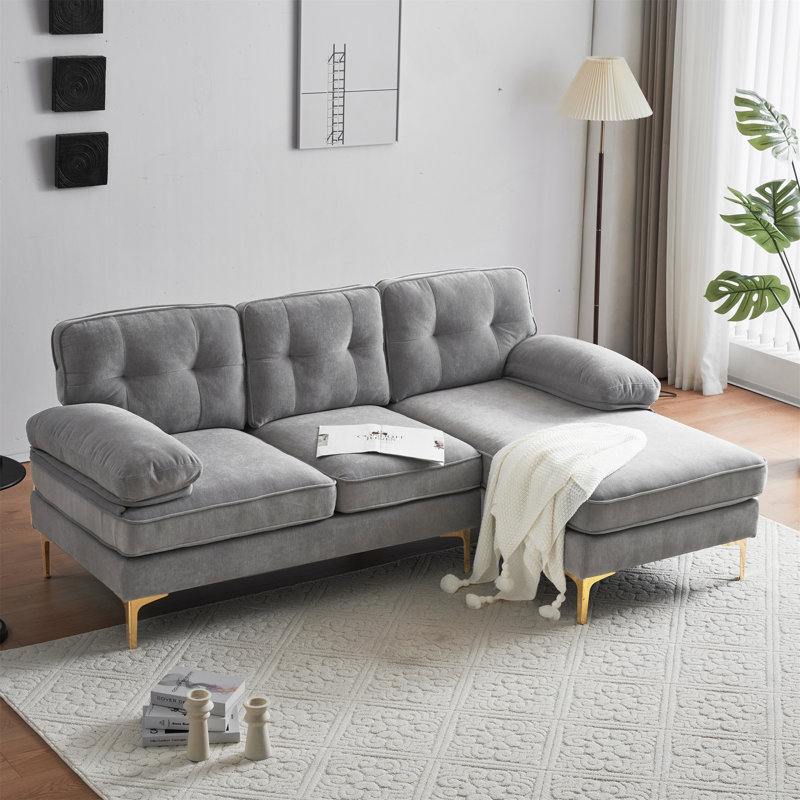 Canapé luxueux rembourré en forme de L en velours avec coussins amovibles et structure robuste, parfait pour les décors modernes et rétro.