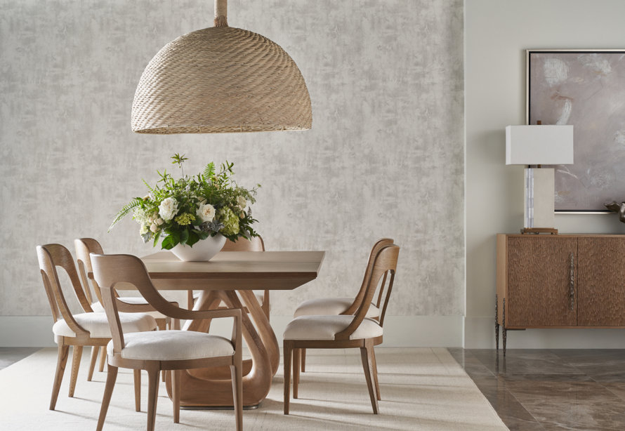 Dining room featuring wooden chairs and a floral centerpiece under a woven pendant light.