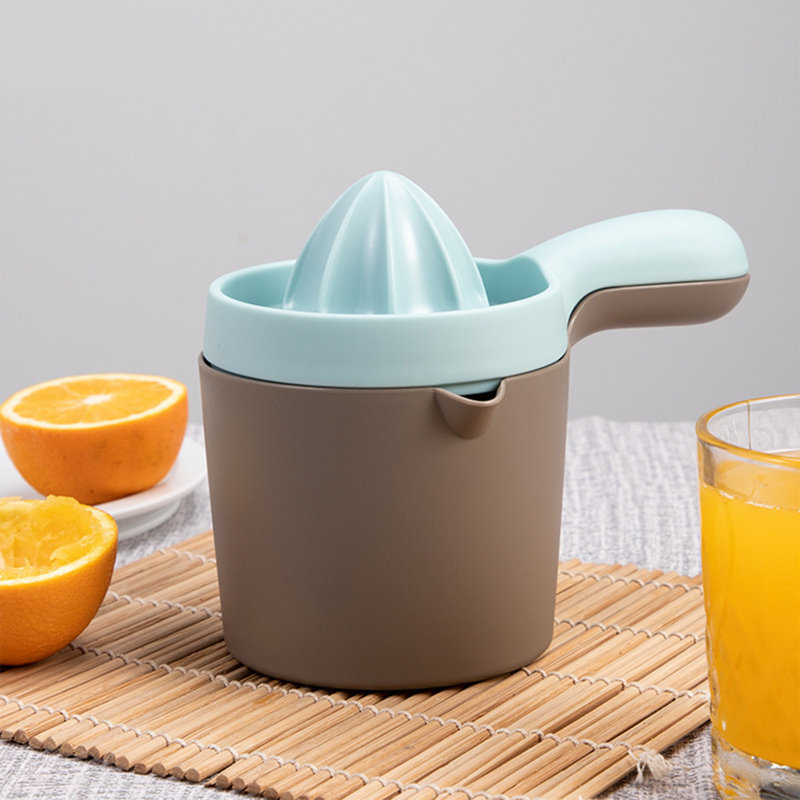 Presse-agrumes manuel pressant la tasse à citron avec balance tenant la main et pressant le jus, Gray