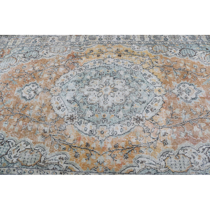 De douces couleurs pastel illuminent les motifs floraux élégants de ce tapis turc rétro intemporel