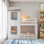 Lit superposé simple au-dessus d'un lit simple en bois avec toit, fenêtre, garde-corps et échelle