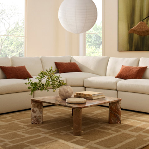 Living room with white sectional and square coffee table.