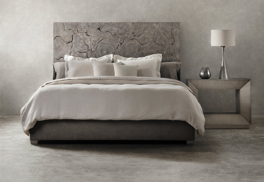 Upholstered bed with a decorative wood headboard.