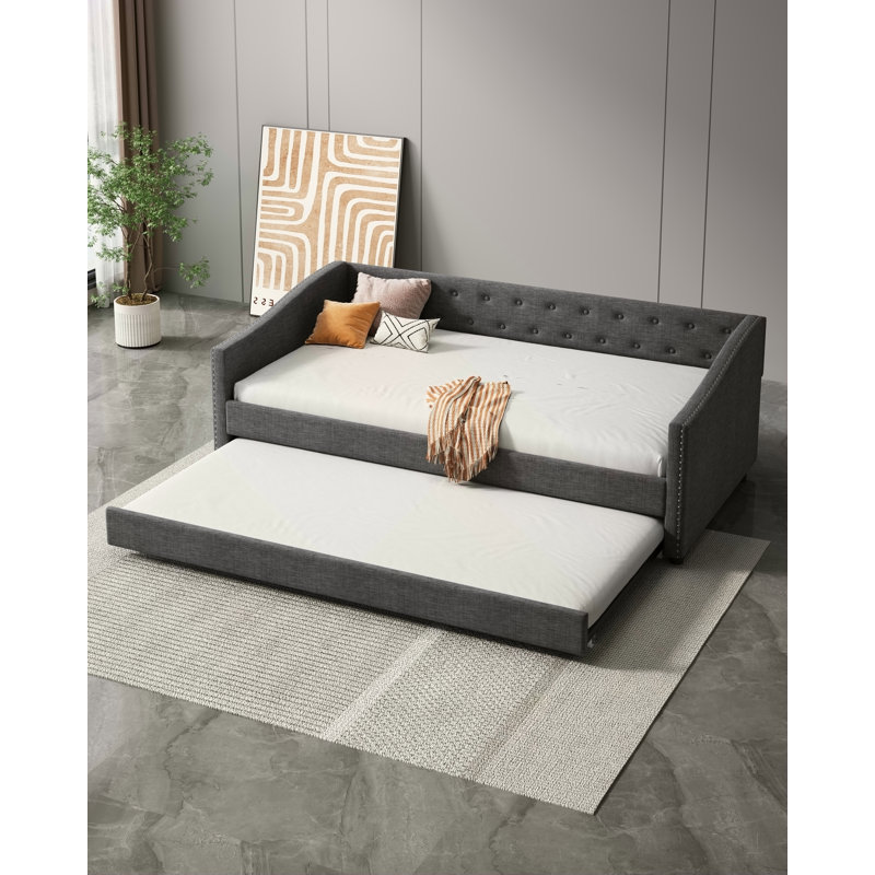 Lit de jour simple avec lit gigogne, canapé-lit capitonné, dossier à boutons, accoudoirs cloutés en cuivre, gris foncé