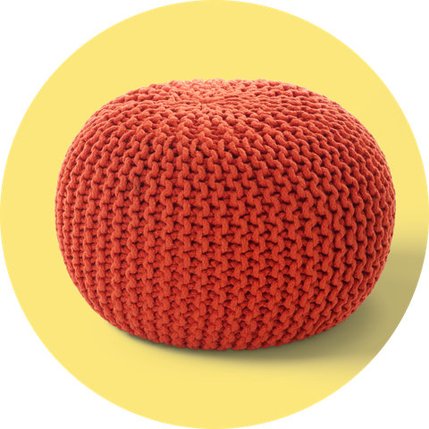 A round, textured knit pouf ottoman in dark orange, displayed on a circular yellow background.