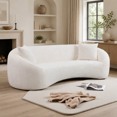 Canapé minimaliste et incurvé à trois places, revêtu d'un tissu bouclé doux et doté d'une assise profonde et confortable en forme de nuage.