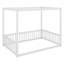 Un lit à baldaquin avec des barrières de sécurité structure une chambre minimaliste avec une élégance ludique