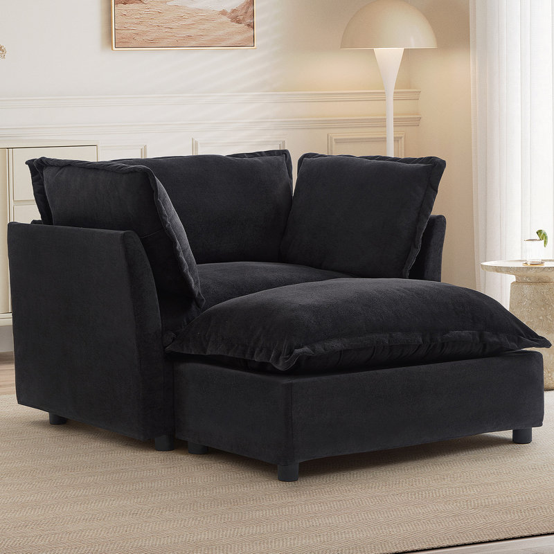 Fauteuil moderne avec repose-pieds mobile, siège large, accoudoirs courbés et coussins moelleux pour un salon et une chambre à coucher confortables