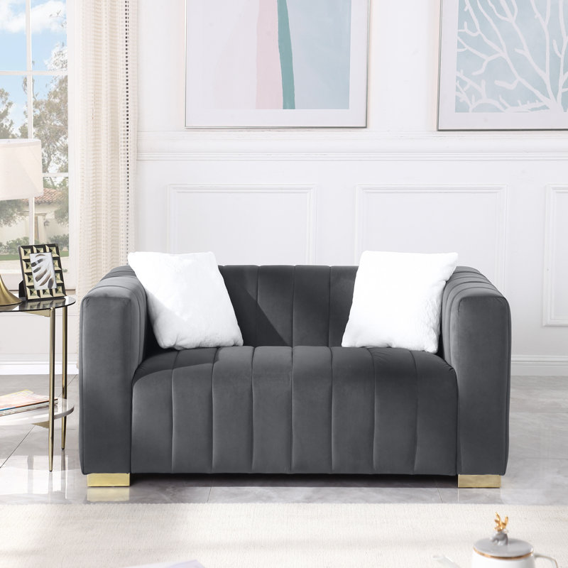 Un canapé-lit moderne sur un Chesterfield traditionnel de couleur grise