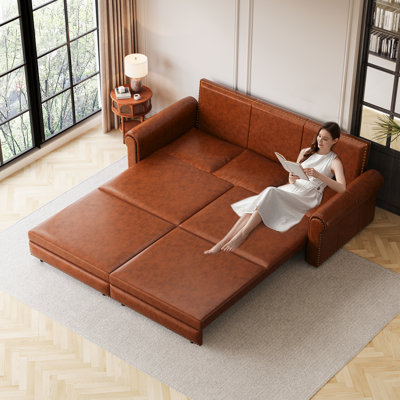 Canapé-lit convertible 3-en-1 avec mécanisme de très grand lit escamotable, revêtement en similicuir, garniture cloutée, accoudoirs roulés et coussins amovibles pour une utilisation polyvalente.