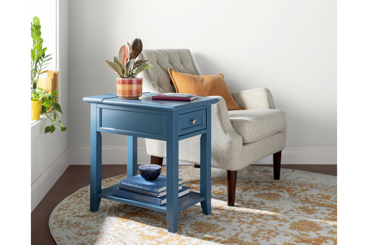 blue wood side table next to a white upholstered accent seat, all placed on a circular area rug