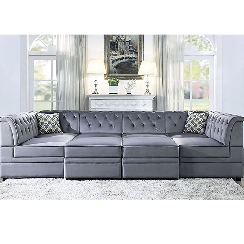 Fauteuil gris sans accoudoirs en velours avec capitonnage à boutons pour un salon élégant