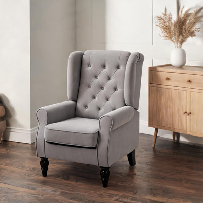Fauteuil d'appoint individuel en tissu gris neutre avec dossier capitonné et pieds en bois massif fini lustré