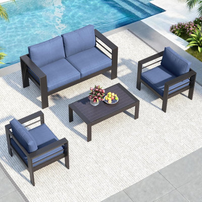 Ensemble de conversation pour patio 4 pièces en aluminium, 4 places, structure en fonte d'aluminium noire, coussins bleus, table basse WPC, causeuse 50 po + 2 fauteuils