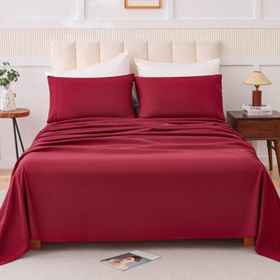Ensemble quatre pièces rouge vin en mélange de coton, confort moelleux pour dormir nu, bords renforcés pour éviter l'effilochage, couleurs peu saturées, disponible en différentes tailles de lit, impression végétale.