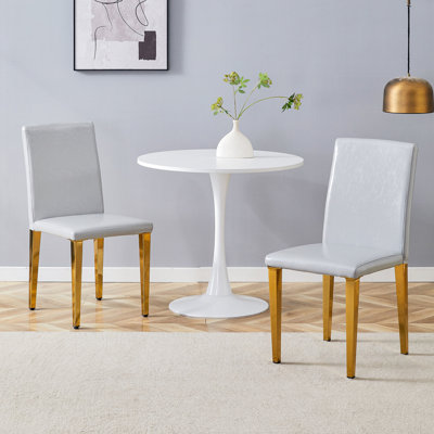 Ensemble de 2 chaises de salle à manger en polyuréthane gris clair: hauteur de 35,4 po, dossier ergonomique de 18,5 po, siège en éponge de 17 po x 16 po, parfait pour la salle à manger, le bureau personnel et l'espace de vie, élégant et confortable. Pieds en métal doré.