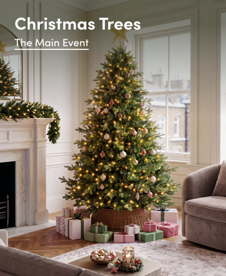 Christmas Trees The Main Event featuring a decorated tree with soft pink ornaments and warm lights in a festive living room setting with wrapped gifts.