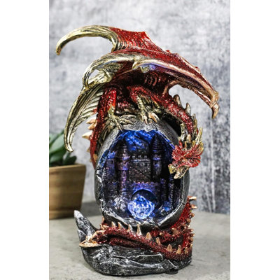 Figurine fantaisie en forme de dragon rouge sur un œuf géant à DEL avec château médiéval