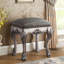 Tabouret de coiffeuse gris avec pieds blanc os rétro, accents glamour de chambre à coucher, essentiel