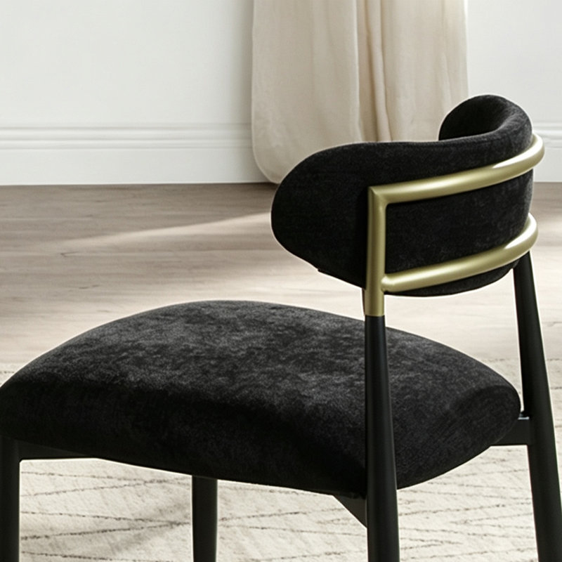 Chaise de salle à manger moderne et minimaliste, revêtue de tissu noir, avec dossier cylindrique incurvé et pieds en métal.
