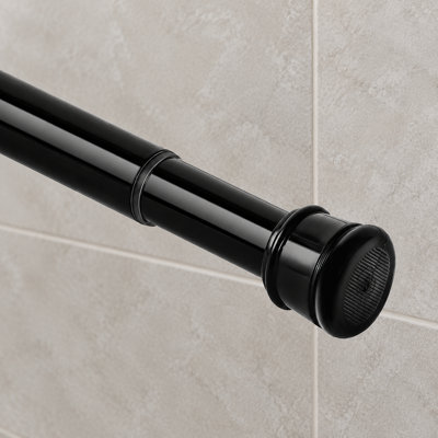 Une tringle à rideau de douche noire à ressort, réglable de 27 à 82 pouces avec un diamètre de 1 pouce ; sa conception longue, sans perçage et antirouille, à tension, convient aux salles de bain, aux fenêtres et aux placards.