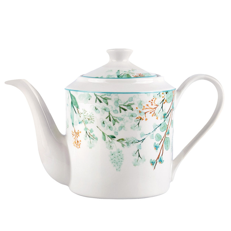 Théière en porcelaine et feuilles vertes