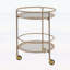Chariot-bar rond avec tablettes en verre trempé et accents dorés, finition blanche vieillie, idéal pour les décors modernes et rétro