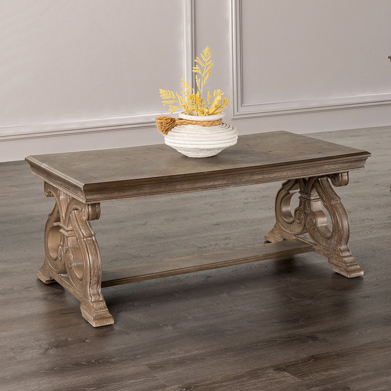 Table basse de style traditionnel avec pieds à volutes courbés et finition chêne vieilli, parfaite pour les salons élégants