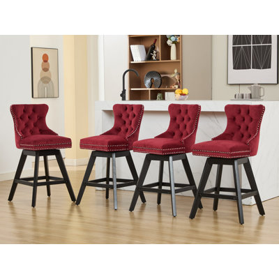 Ensemble de 2 tabourets de bar pivotants en velours rouge vin, capitonnés, pieds en bois et garniture cloutée chromée