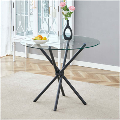 Une table ronde circulaire en verre trempé transparent d'un diamètre de 36,6 pouces, avec des pieds en métal froncés en forme d'anneau. Le verre du bureau a une épaisseur de 0,3 pouce