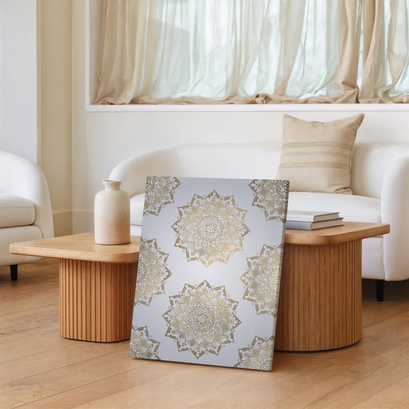 La toile crée un motif sans couture avec des motifs de mandala complexes dans un art mural doux, des tons or et crème fixés contre une lumière subtile