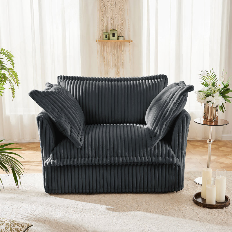 Fauteuil à revêtement antidérapant avec coussin de dossier généreux et plusieurs coussins décoratifs, offrant un confort d'assise profond pour des moments de détente.