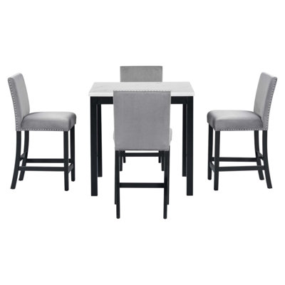Ensemble de salle à manger 5 pièces avec table haute, un plateau en faux marbre et quatre chaises recouvertes de velours, parfait pour des réunions de famille élégantes.