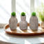 S / 3 petits vases de sable et de ciment brun avec motifs sculpturaux A: 3,7 x 3,7 x 6 po B: 3,5 x 3,5 x 6 po C: 3,7 x 3,7 x 6 po