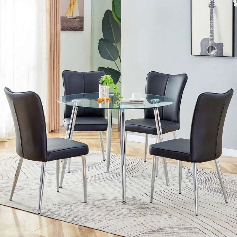 Ensemble de table et de chaises.Une table de salle à manger ronde en verre trempé transparent de 38,6 po de diamètre - Pieds en métal argenté. Comprend 4 chaises en polyuréthane noir avec un motif à rayures verticales sur le dossier.