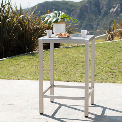 Table de bar d'extérieur avec structure en aluminium gris et dessus en verre : cette affirmation est totalement inexacte. Une table de bar extérieure n'est pas conçue pour résister aux tremblements de terre. Rouille