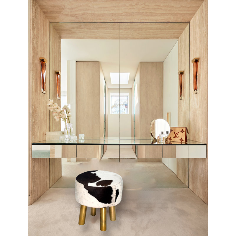 Tabouret en cuir de vache noir et blanc avec pieds dorés