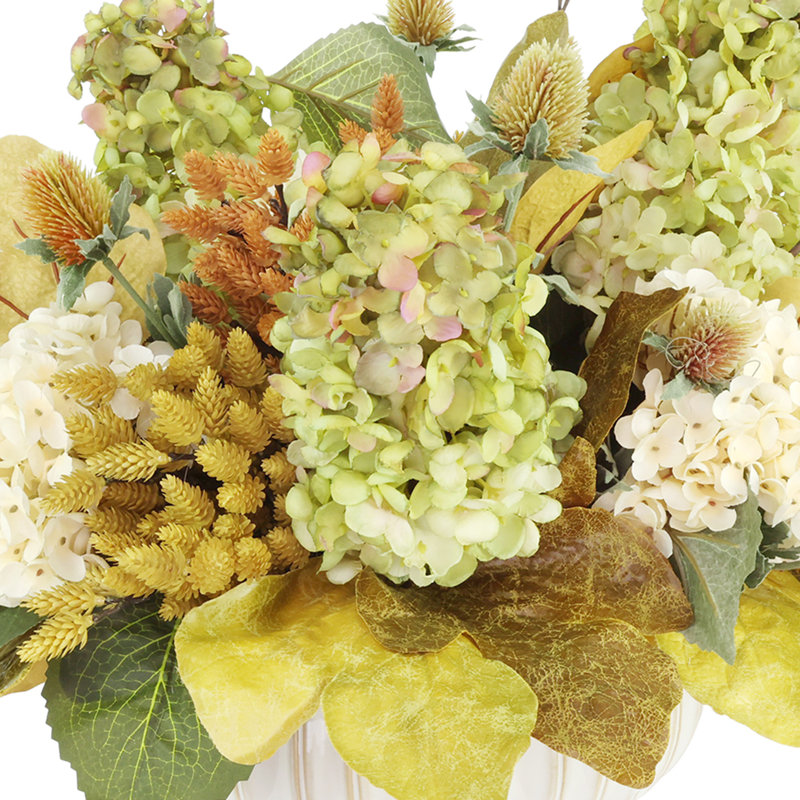 Arrangement d'automne avec hortensias, pommes de pin et chardon dans un pot en céramique