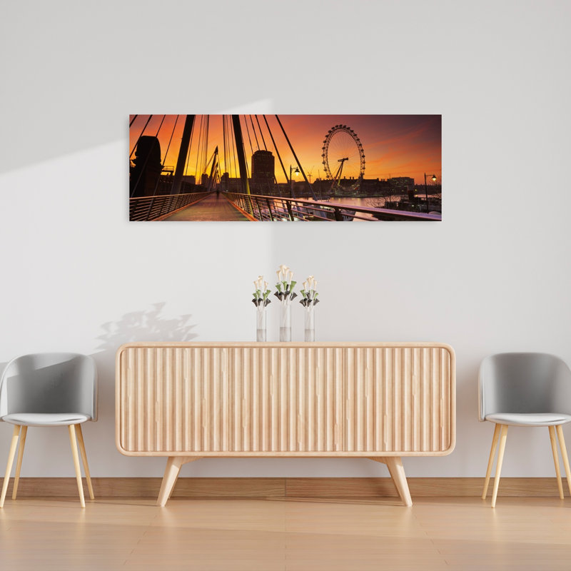 Bridge Across A River With A Ferris Wheel In The Background Golden Jubilee Bridge Thames River Millennium Wheel City Of Westminster London England by Mark Denton - Wrapped Canvas Panoramic Print