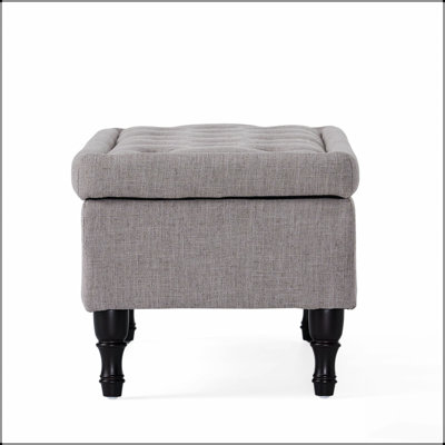 Repose-pieds capitonné moelleux en tissu gris doux, parfait pour le confort et le rangement caché dans les intérieurs modernes.
