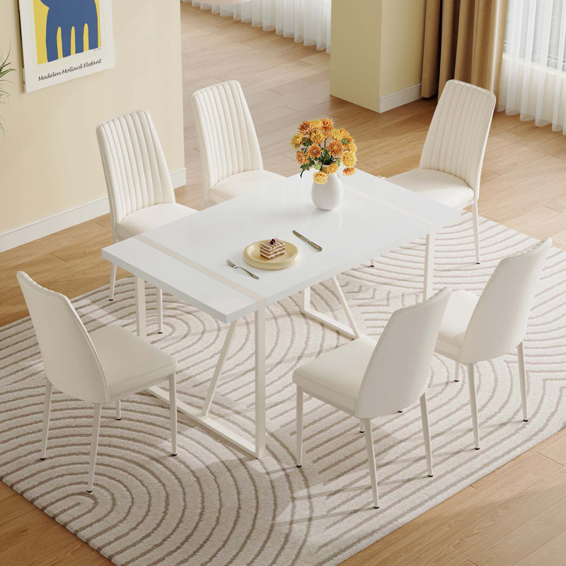 Ensemble de table de salle à manger en MDF blanc crème avec chaises sans accoudoirs. Le dossier de la chaise de salle à manger est conçu avec de multiples rayures verticales, ajoutant une atmosphère chaleureuse à votre famille.