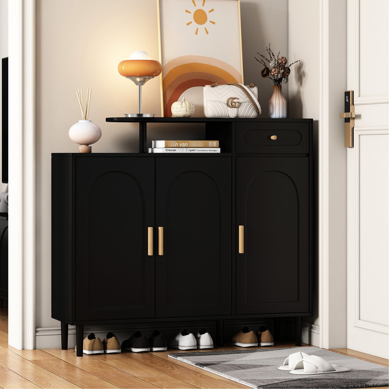 Armoire à chaussures Adonis Chic avec façade arquée et tiroir. Noir, tablettes réglables, grand espace de travail, portes de rangement noires en panneau de particules. Grand bureau, construction