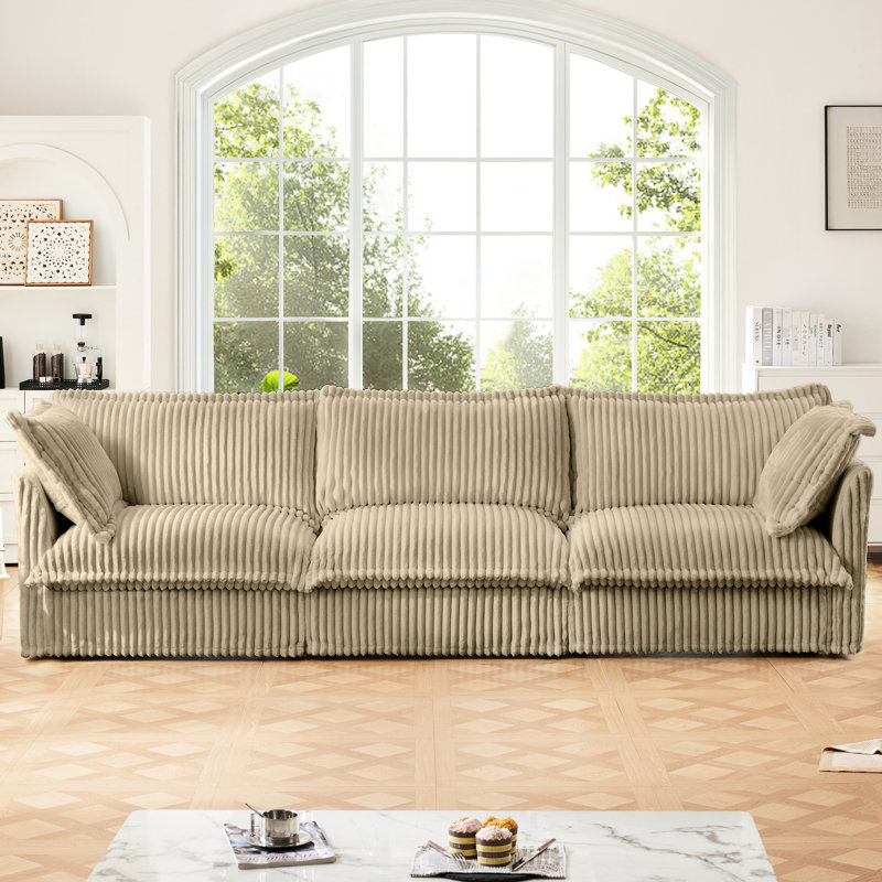 Luxueux canapé trois places - Velours côtelé camel avec assise profonde et coussins pour un confort optimal, ambiance douce et chaleureuse.