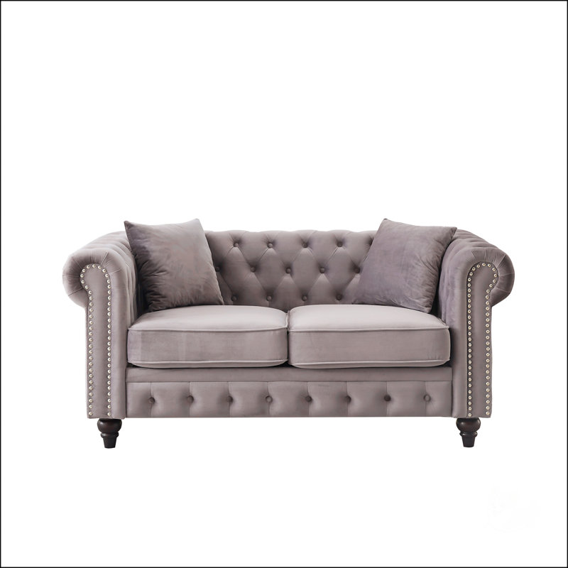 Luxueux canapé Chesterfield en velours avec capitonnage à boutons et garniture cloutée, parfait pour les salons modernes et élégants.
