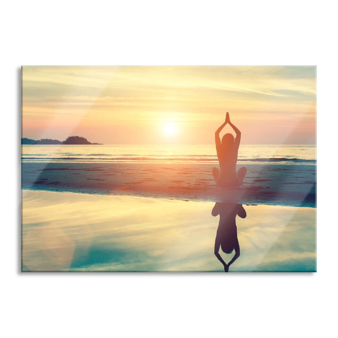 Glasbild Frau in Yoga-Pose am Strand